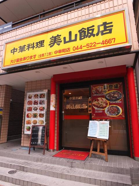 中華料理美山飯店の黄色い看板と赤い柱の入口を近くから見た外観